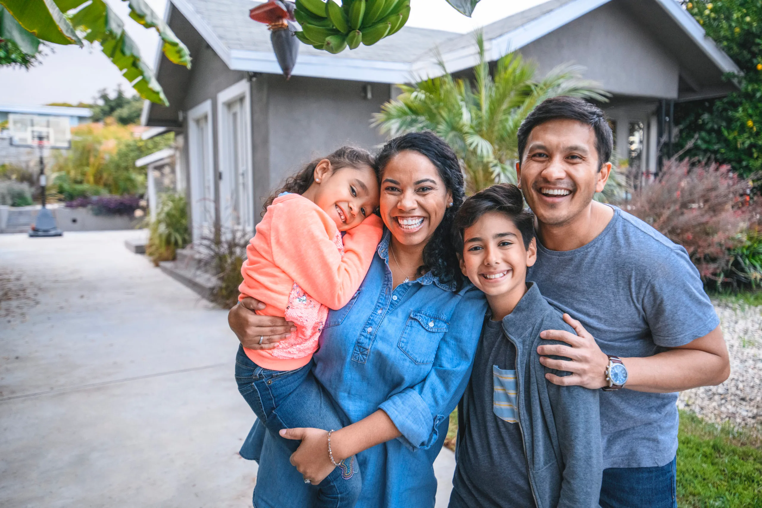 Family of four smiling happily following a window replacement