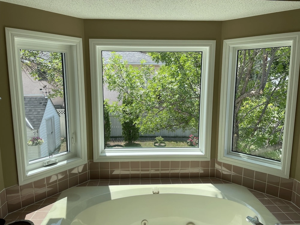 Three windows surrounding a bathtub