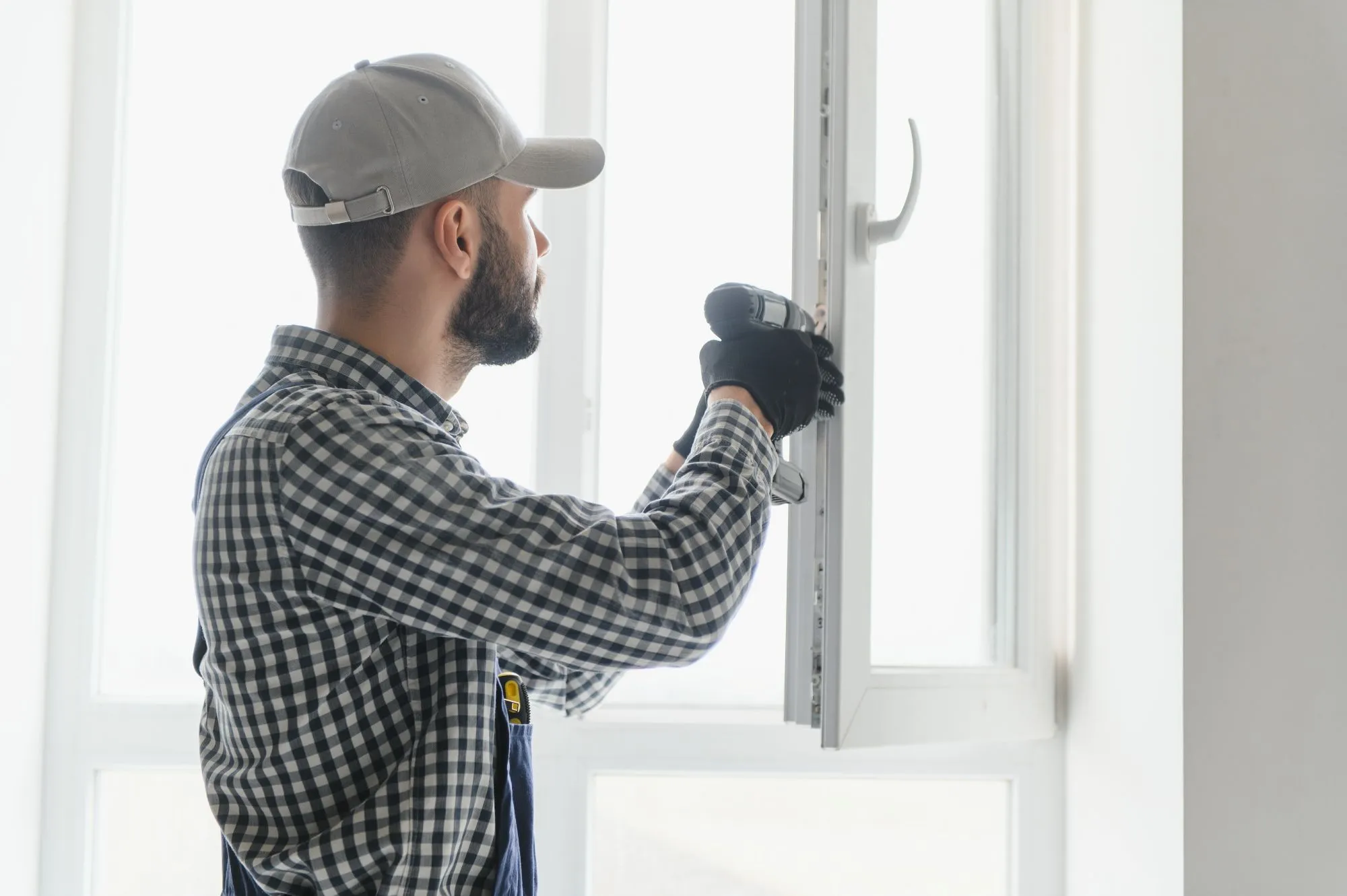 Installer fitting and sealing a replacement window in a Calgary home.